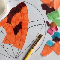 Sticking tissue paper on a template to create a stained glass butterfly design