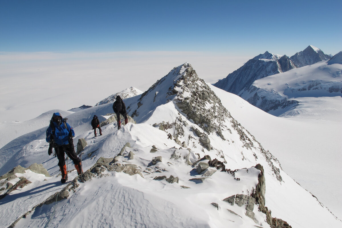 Climbers work their way along the rocky summit ridge