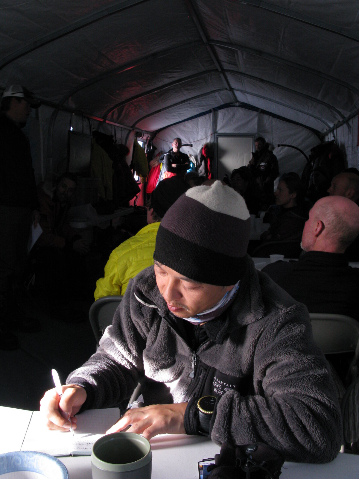 Guests journals inside dining tent at ALE's South Pole Camp