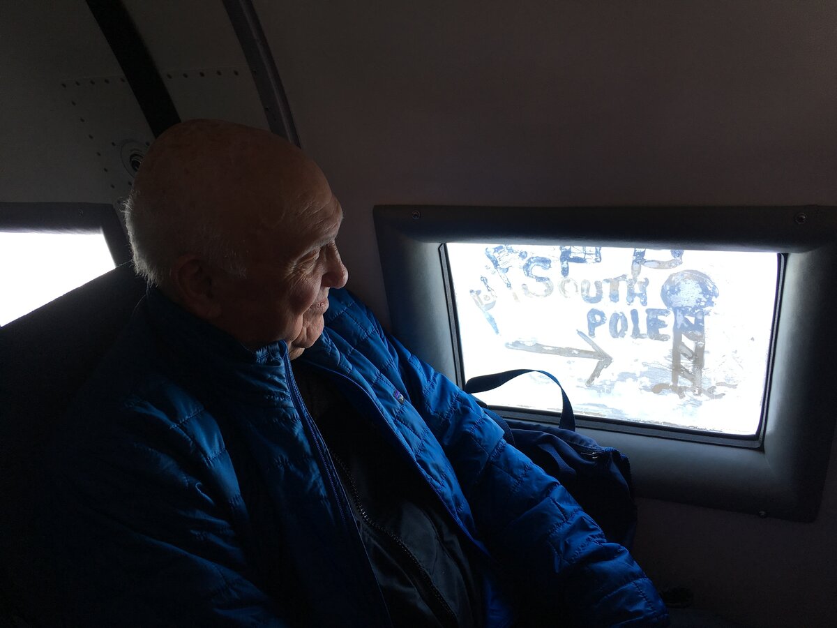A passenger looks out the frozen window of the Basler where he has written South Pole